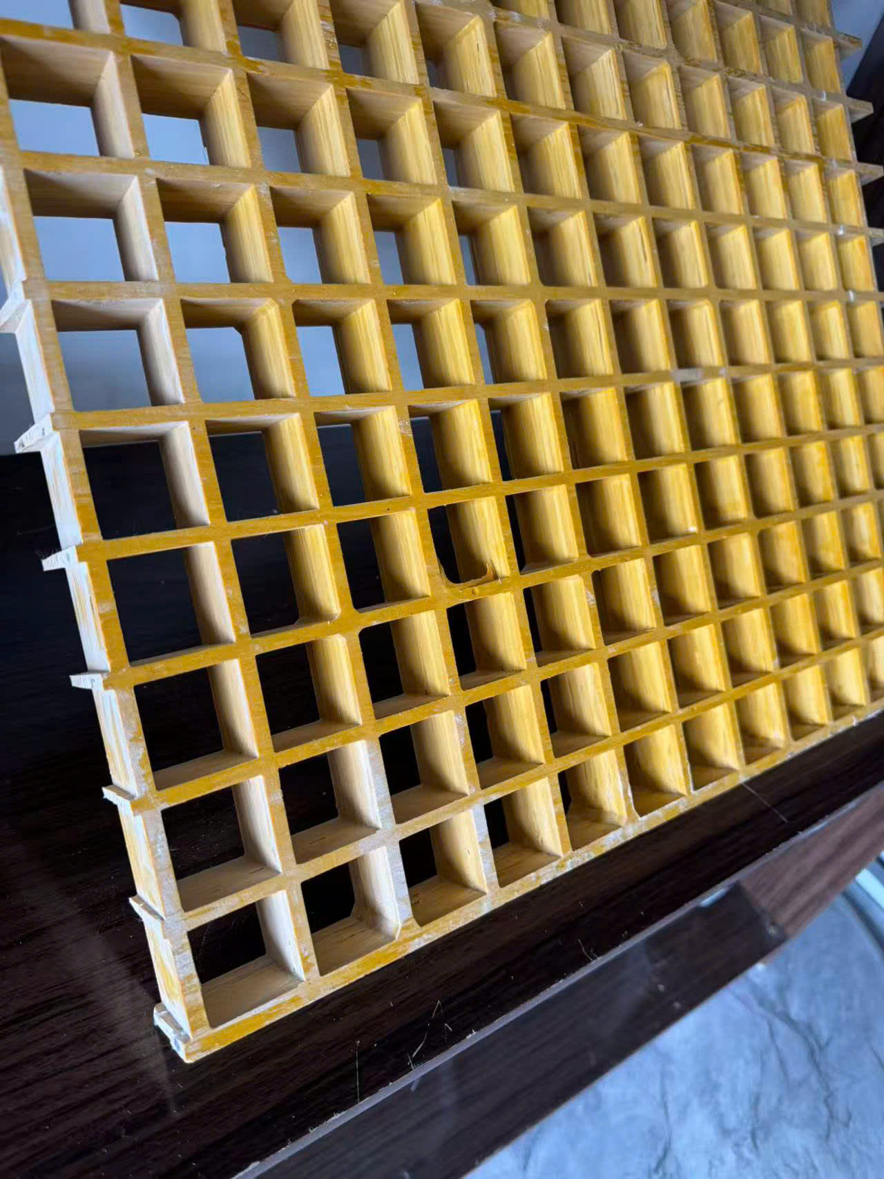 Cận cảnh ô lưới của tấm sàn grating FRP màu vàng