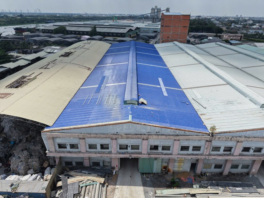 Hệ mái xanh dương giữa các mái nhà xưởng nhìn từ trên cao.